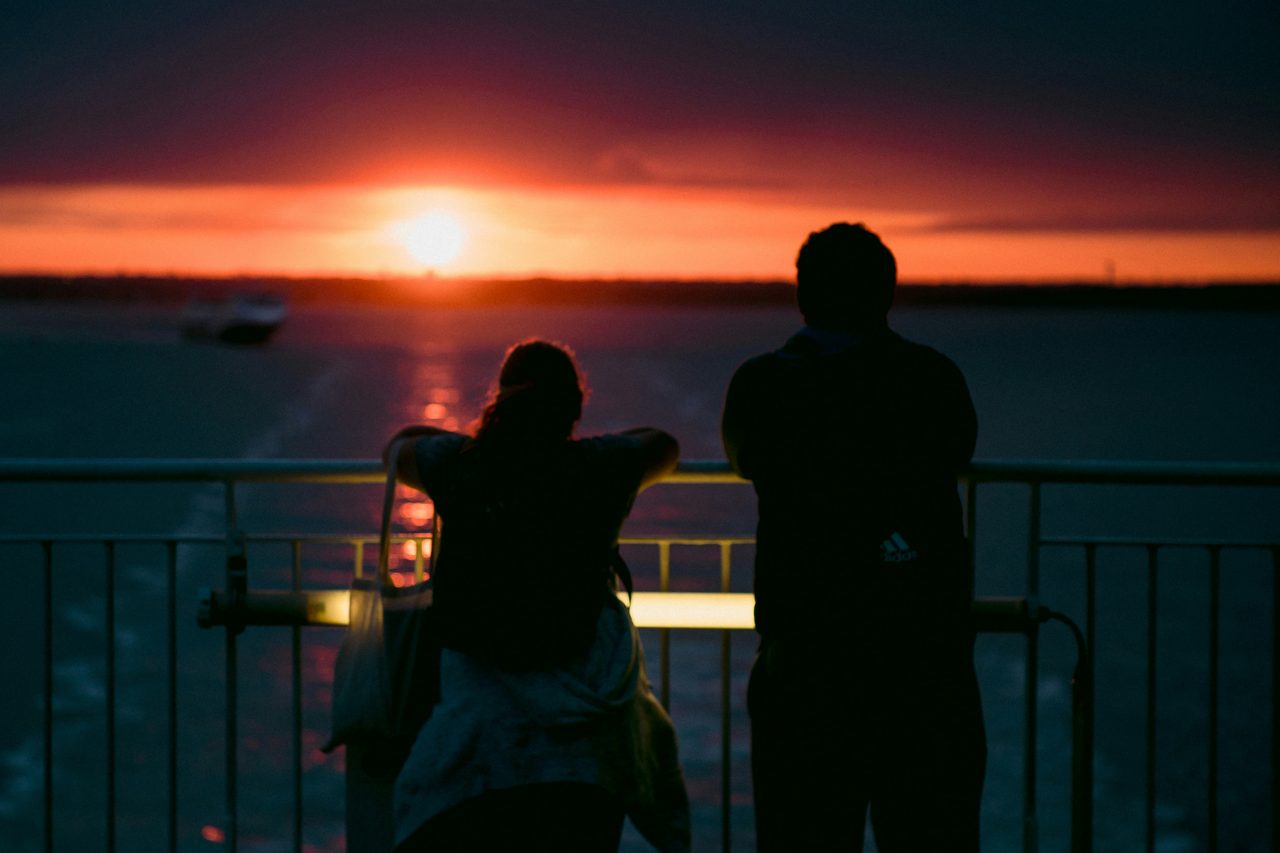 Couple on a sailboat at sunset off Barcelona